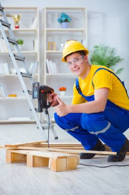 Ahşap palet montajı yapan genç adam.