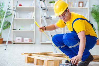 Ahşap palet montajı yapan genç adam.