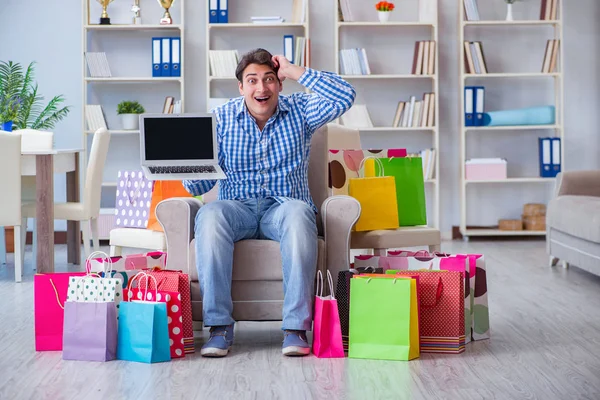 Ung man efter överdriven shopping hemma — Stockfoto