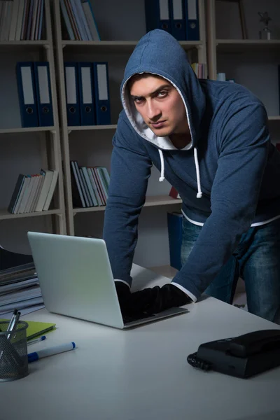 Молодий хакер зламав комп'ютер вночі — стокове фото