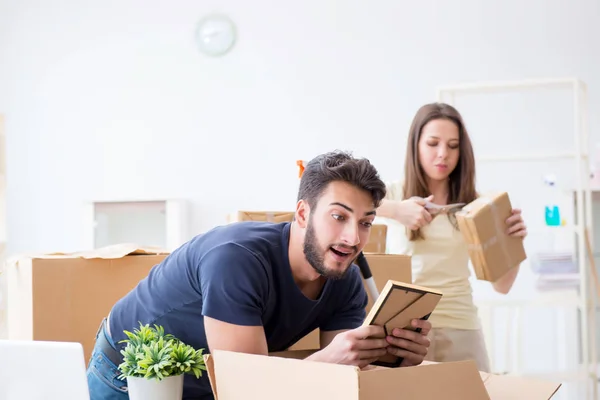 Familia joven desempacando en casa nueva con cajas — Foto de Stock