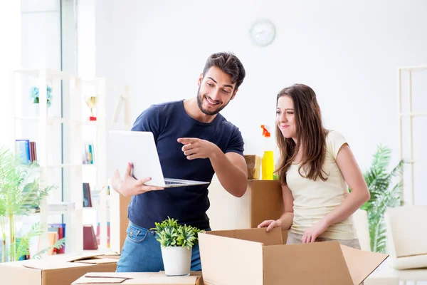 Ung familj packar upp i nytt hus med lådor — Stockfoto