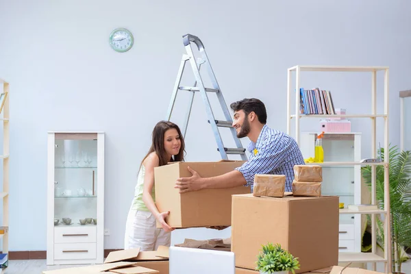 Jonge familie uitpakken bij nieuw huis met dozen — Stockfoto