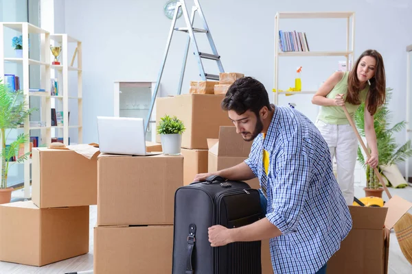 Famiglia giovane disfare le valigie in una nuova casa con scatole — Foto Stock