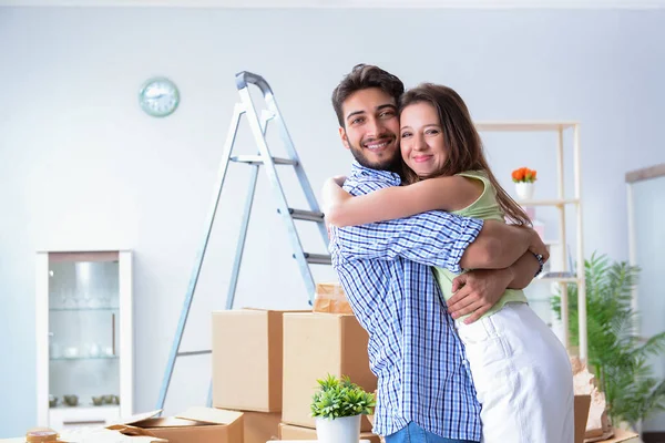 Familia joven desempacando en casa nueva con cajas —  Fotos de Stock