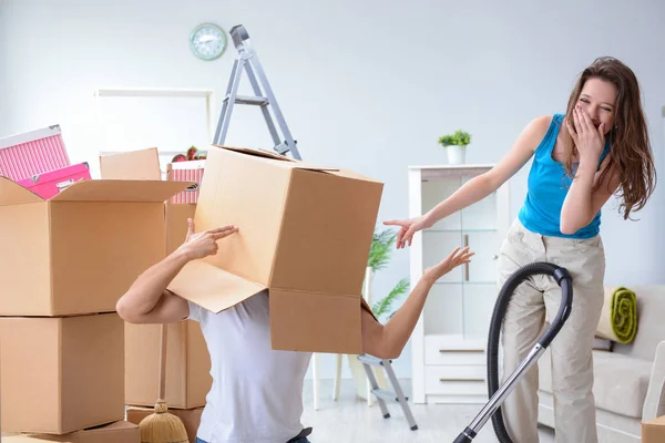 Familia joven desempacando en casa nueva con cajas —  Fotos de Stock