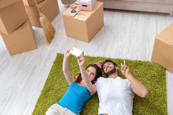 Familia joven desempacando en casa nueva con cajas —  Fotos de Stock