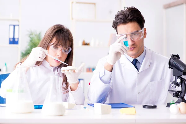 Dois médicos de laboratório testando produtos alimentares — Fotografia de Stock