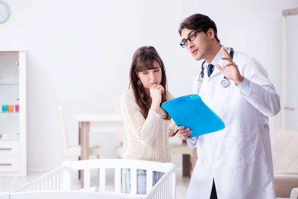 Doctor explaining to young mother — Stock Photo, Image