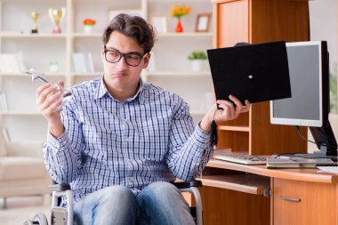 Engelli öğrenci evde tekerlekli sandalyede çalışıyor.