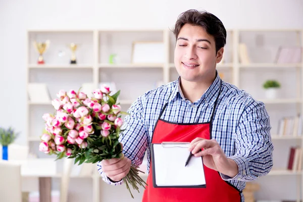 Asistente de floristería ofreciendo un ramo de flores — Foto de Stock