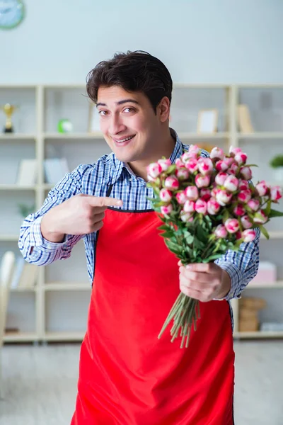 Asistente de floristería ofreciendo un ramo de flores — Foto de Stock