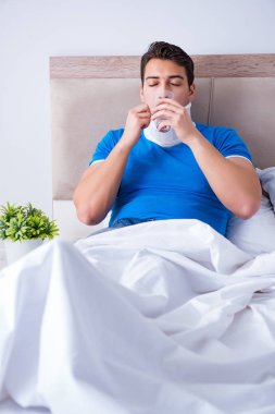 Yatakta boynu yaralanmış genç bir adam.