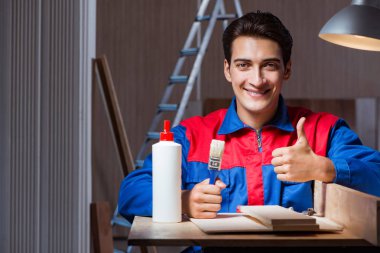 Genç adam ahşap parçaları DIY konseptinde yapıştırıyor.