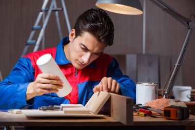 Genç adam ahşap parçaları DIY konseptinde yapıştırıyor.