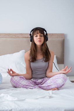 Genç bir aile yatak odasında meditasyon yapıyor.