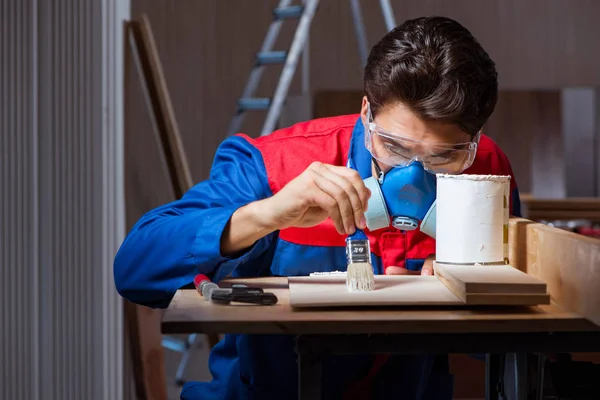 Jeune homme collant des pièces de bois ensemble dans le concept de bricolage — Photo