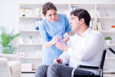 Tekerlekli sandalyedeki hasta düzenli kontrol için doktoru ziyaret ediyor.