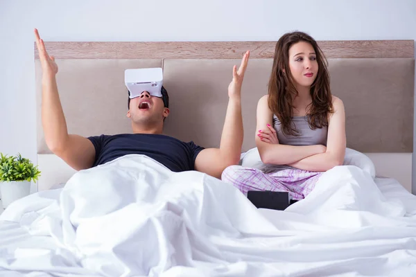Esposa e marido com óculos de realidade virtual na cama — Fotografia de Stock