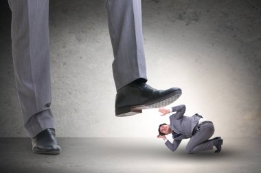 Kötü patron iş konseptinde çalışanın üzerine basıyor.