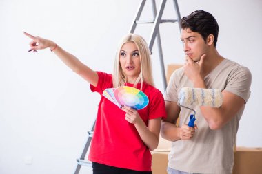 Ev tadilatı sırasında genç bir aile boya işi yapıyor.