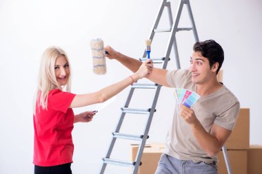 Ev tadilatı sırasında genç bir aile boya işi yapıyor.