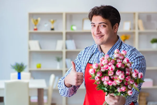 Asistente de floristería ofreciendo un ramo de flores — Foto de Stock