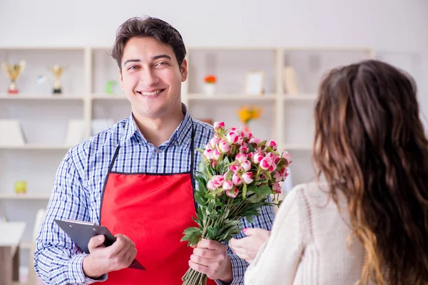 Asistente de floristería vendiendo flores a cliente femenino — Foto de Stock