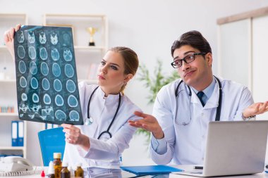 İki doktor teşhis için hastanın röntgen görüntülerini inceliyor.