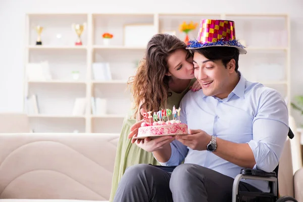 Young family celebrating birthday with disabled person