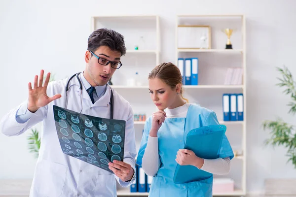Dwóch lekarzy badających zdjęcia rentgenowskie pacjenta w celu rozpoznania — Zdjęcie stockowe
