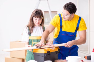 Ahşap atölyesinde kadın marangozluk ipuçlarını açıklayan adam