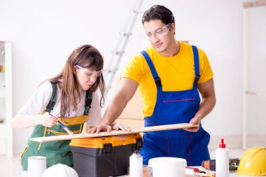 Ahşap atölyesinde kadın marangozluk ipuçlarını açıklayan adam