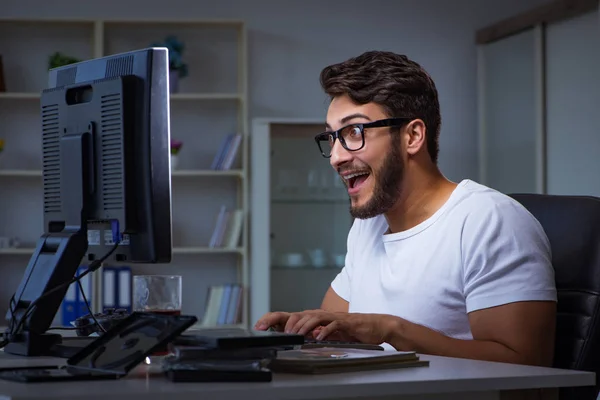 Genç adam fazla mesai yapmak için geç saatlere kadar ofiste kalıyor. — Stok fotoğraf