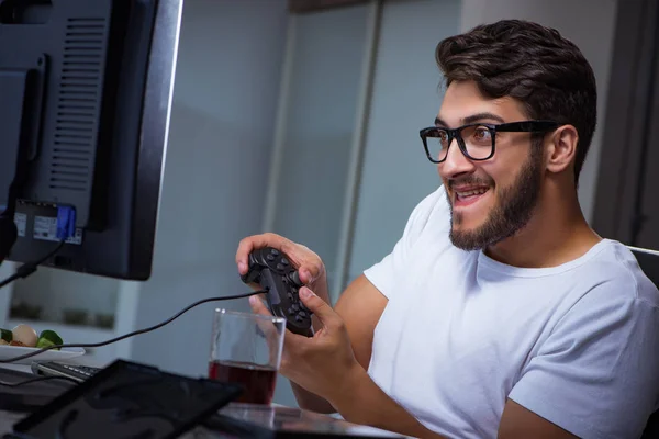 Молодой человек играет в игры долгие часы в офисе — стоковое фото