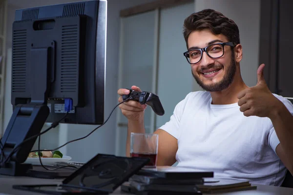 Jovem jogando jogos longas horas atrasado no escritório — Fotografia de Stock