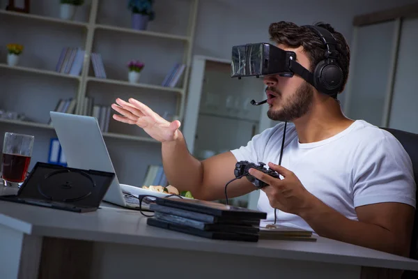 Jovem jogando jogos longas horas atrasado no escritório — Fotografia de Stock