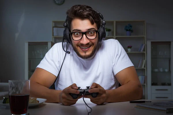 Jovem jogando jogos longas horas atrasado no escritório — Fotografia de Stock