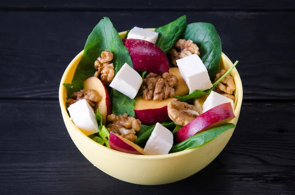 Salada de espinafre com nozes e maçãs servidas na mesa — Fotografia de Stock