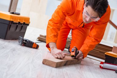 Müteahhit lamine ahşap zemin üzerinde çalışıyor. 