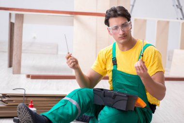 Müteahhit lamine ahşap zemin üzerinde çalışıyor. 