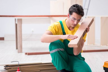 Müteahhit lamine ahşap zemin üzerinde çalışıyor. 