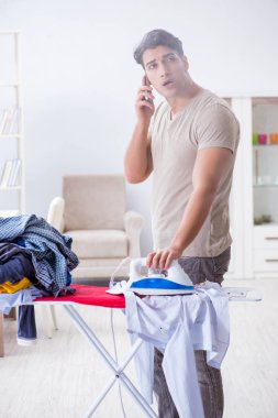 Dikkatsiz koca ütü yaparken giysilerini yakıyor.