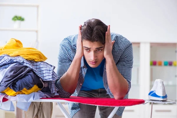 Joven marido haciendo planchado de ropa en casa — Foto de Stock