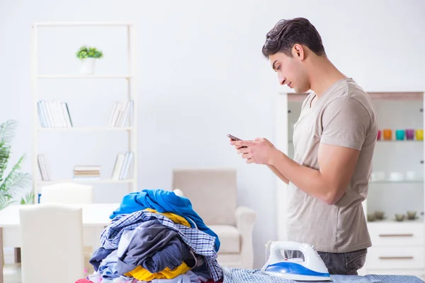 Genç adam evde çamaşır ütülüyor. — Stok fotoğraf
