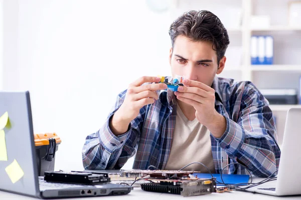 Professional repairman repairing computer in workshop