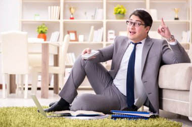 İş adamı evde yerde çalışıyor.