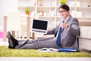 İş adamı evde yerde çalışıyor.