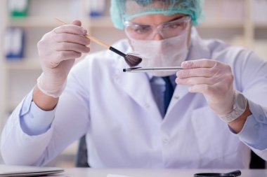 Adli tıp dedektifi suç delilleri üzerinde çalışıyor.