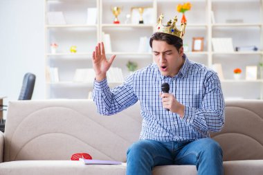 Evde karaoke yapan komik adam.
